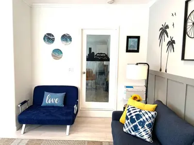 a living room with a blue couch and a chair at King Garden Suite - 10 mins to Beach and LAX in Gardena