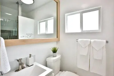 a bathroom with a sink and a toilet and a mirror at King Garden Suite - 10 mins to Beach and LAX in Gardena