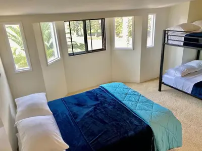 a bedroom with two bunk beds and windows at Modern & Cozy Gem ~ Walk to the Beach ~ Queen Beds in Carpinteria