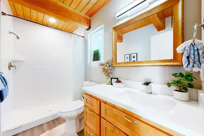 a bathroom with a sink and a toilet and a mirror at Hemlock Haven in Lake Arrowhead