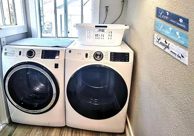 a washing machine and a washer in a room at Beautiful Guesthouse, Sleeps 4 - Kitchen, Private Laundry, AC, Parking, 65' TV, Close to Stores, Restaurants & Beach in Long Beach