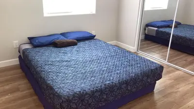 a bedroom with a bed and a mirror at We are in this together in Santa Ana