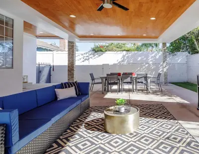 an outdoor patio with a blue couch and a table at New 5 bed w/hot tub close to Universal sleeps 12 in Los Angeles
