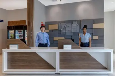 two people standing at a counter in a store at Holiday Inn Express & Suites - Glendale Downtown in Glendale