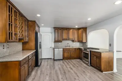 a large kitchen with wooden cabinets and stainless steel appliances at Woodland Hills 3 bedroom w/ pool and spa in Los Angeles