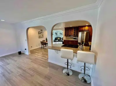 a kitchen and living room with two bar stools at Woodland Hills 3 bedroom w/ pool and spa in Los Angeles