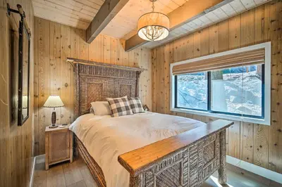 a bedroom with a large bed and a window at Pet-Friendly Retreat with Game Room and Fire Pit! in Lake Arrowhead