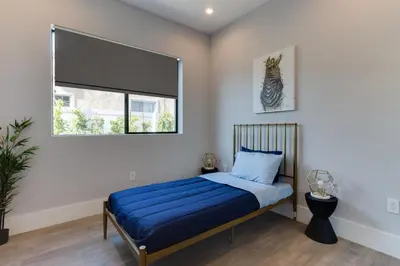 a bedroom with a bed with blue sheets and a window at Modern 5 Bedroom Masterpiece With Rooftop Deck in Los Angeles