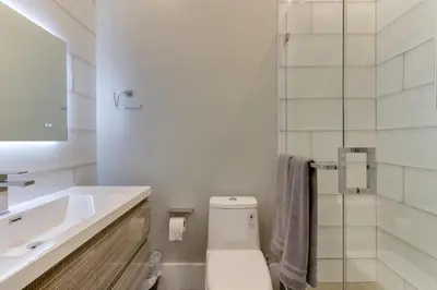 a bathroom with a toilet and a sink and a shower at Modern 5 Bedroom Masterpiece With Rooftop Deck in Los Angeles