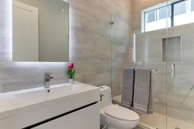 a bathroom with a toilet and a sink and a mirror at Modern 5 Bedroom Masterpiece With Rooftop Deck in Los Angeles