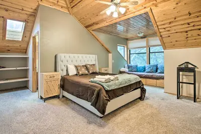 a bedroom with a bed in a room with wooden ceilings at Spacious Pine Mountain Club Cabin with Fire Pit in Pine Mountain Club