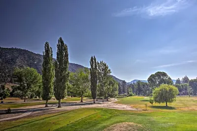 a golf course with trees and mountains in the background at Spacious Pine Mountain Club Cabin with Fire Pit in Pine Mountain Club