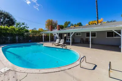 a swimming pool in front of a house at 4 Bedroom West Hills Charmer with Pool in West Hills