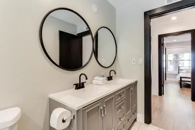 a bathroom with a sink and two mirrors on the wall at 4 Bedroom West Hills Charmer with Pool in West Hills