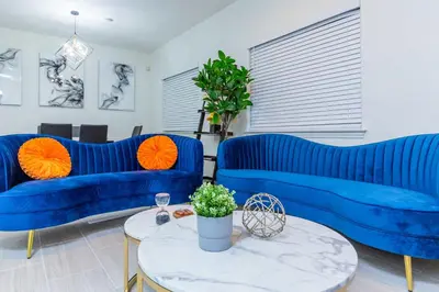 a living room with blue couches and a table at Newly Remodeled 5B4B 2 mile from the Rose Parade in Pasadena