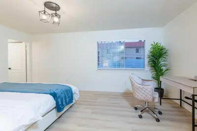 a bedroom with a bed and a desk and a chair at Newly Remodeled 5B4B 2 mile from the Rose Parade in Pasadena