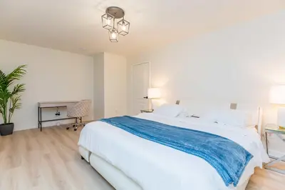a white bedroom with a large bed and a desk at Newly Remodeled 5B4B 2 mile from the Rose Parade in Pasadena