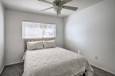 a bedroom with a bed with a ceiling fan at Central Bakersfield Townhome with Private Patio in Bakersfield
