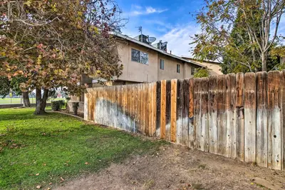 a wooden fence in front of a house at Central Bakersfield Townhome with Private Patio in Bakersfield