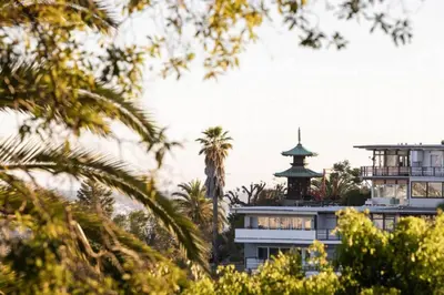 a building with a wrap around porch and palm trees at Hollywood Hideaway in Los Angeles