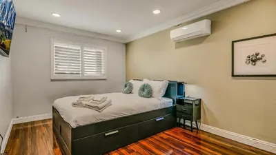 a small bedroom with a bed and a window at Luxury Home 5 Bedrooms with Private Pool Near Huntington Beach in Santa Ana