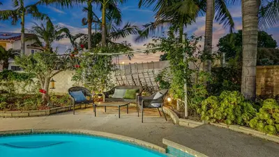 a patio with chairs and a table and a pool at Luxury Home 5 Bedrooms with Private Pool Near Huntington Beach in Santa Ana