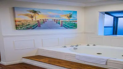 a bathroom with a bath tub and a painting of a pier at Luxury Home 5 Bedrooms with Private Pool Near Huntington Beach in Santa Ana