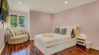 a bedroom with a bed and a chair at Luxury Home 5 Bedrooms with Private Pool Near Huntington Beach in Santa Ana