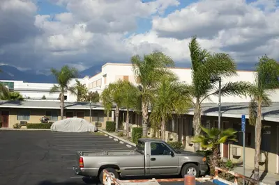 a truck parked in a parking lot in front of a building at Sands Motel by Ontario Airport & Toyota Arena in Ontario