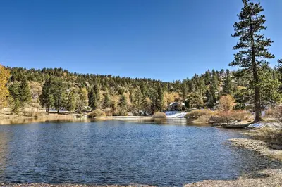 a lake in the middle of a forest at Cozy A-Frame with Hot Tub Near Arrowbear Lake! in Running Springs