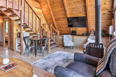 a living room with a couch and a table at Cozy A-Frame with Hot Tub Near Arrowbear Lake! in Running Springs