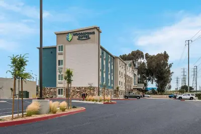 a building with a sign on the side of it at WoodSpring Suites Bellflower - Los Angeles in Bellflower