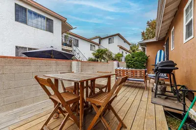 a wooden deck with a table and chairs on it at Spacious Two Bedroom in Santa Monica #E in Los Angeles