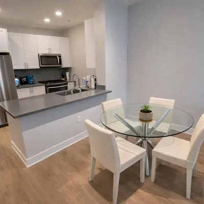 a kitchen and dining room with a glass table and chairs at Luxury 2 Bedrooms 2 Bathrooms With Pool and Gym in Los Angeles