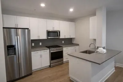 a kitchen with white cabinets and a stainless steel refrigerator at Luxury 2 Bedrooms 2 Bathrooms With Pool and Gym in Los Angeles