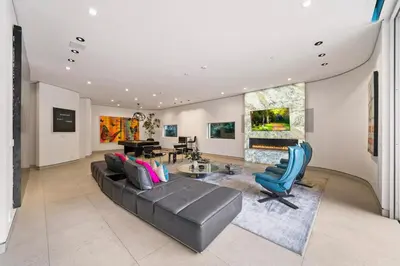 a living room with a black leather couch and blue chairs at Chantilly Lace in Los Angeles