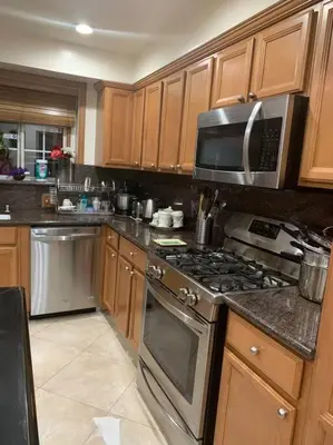 a kitchen with stainless steel appliances and wooden cabinets at Luxury Oasis Home w/Pool Near CSUN-6 Guests in North Hills