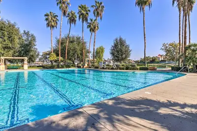 a swimming pool with palm trees in the background at Family-Friendly Getaway Community Amenities! in Bakersfield