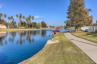 a river with ducks in a park with palm trees at Family-Friendly Getaway Community Amenities! in Bakersfield
