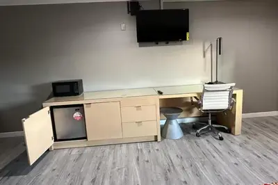 a desk with a television and a chair in an office at Stay Inn Motel in Harbor City