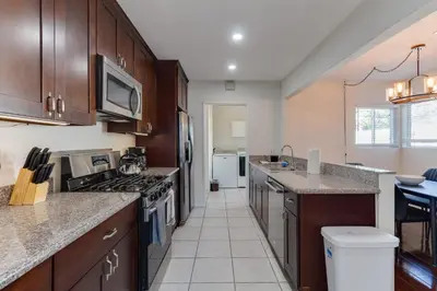 a kitchen with wooden cabinets and a stove top oven at 5 Bedroom Charmer with Pool in Reseda