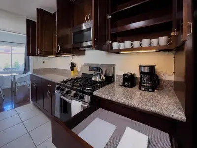 a kitchen with wooden cabinets and a stove top oven at 5 Bedroom Charmer with Pool in Reseda