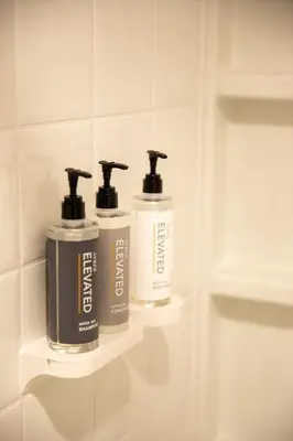 two bottles ofodorizers sitting on shelves in a bathroom at Ayres Hotel Rialto Fontana in Rialto