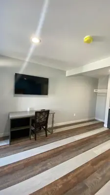a room with a desk and a tv on the wall at Plaza Inn Motel - Los Angeles area in Rosemead