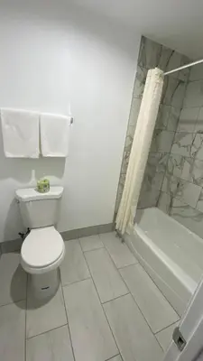 a bathroom with a toilet and a bath tub at Plaza Inn Motel - Los Angeles area in Rosemead