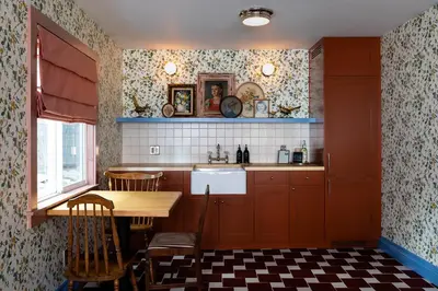 a kitchen with red cabinets and a table and a sink at NP Boutique Lodge in Big Bear Lake