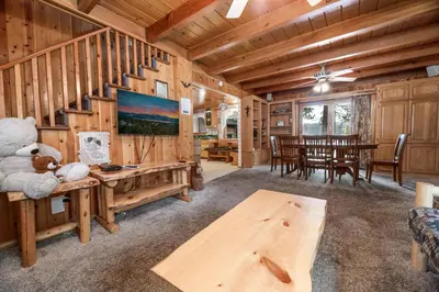a living room with a staircase in a log cabin at Narrow Escape - Close to Lake and Slopes in Big Bear Lake