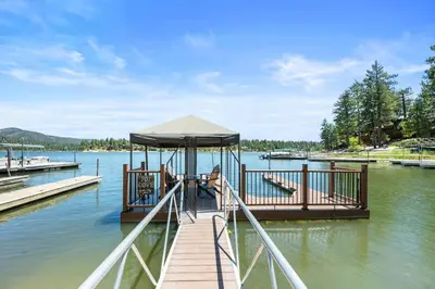 a boat is docked at a dock on the water at Lakefront the Cove - On the Lake in Big Bear Lake