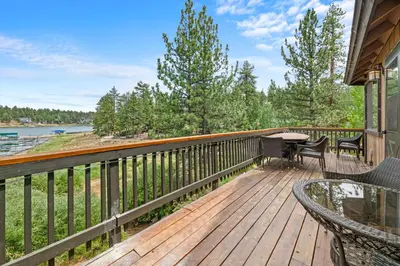 a wooden deck with a table and chairs on it at Lakefront the Cove - On the Lake in Big Bear Lake