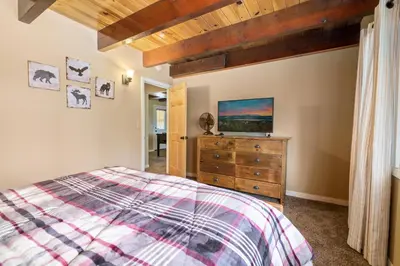 a bedroom with a bed and a dresser with a tv at Lakeview Trout N About - Walk to Lake, Close to Village & Slopes in Big Bear Lake